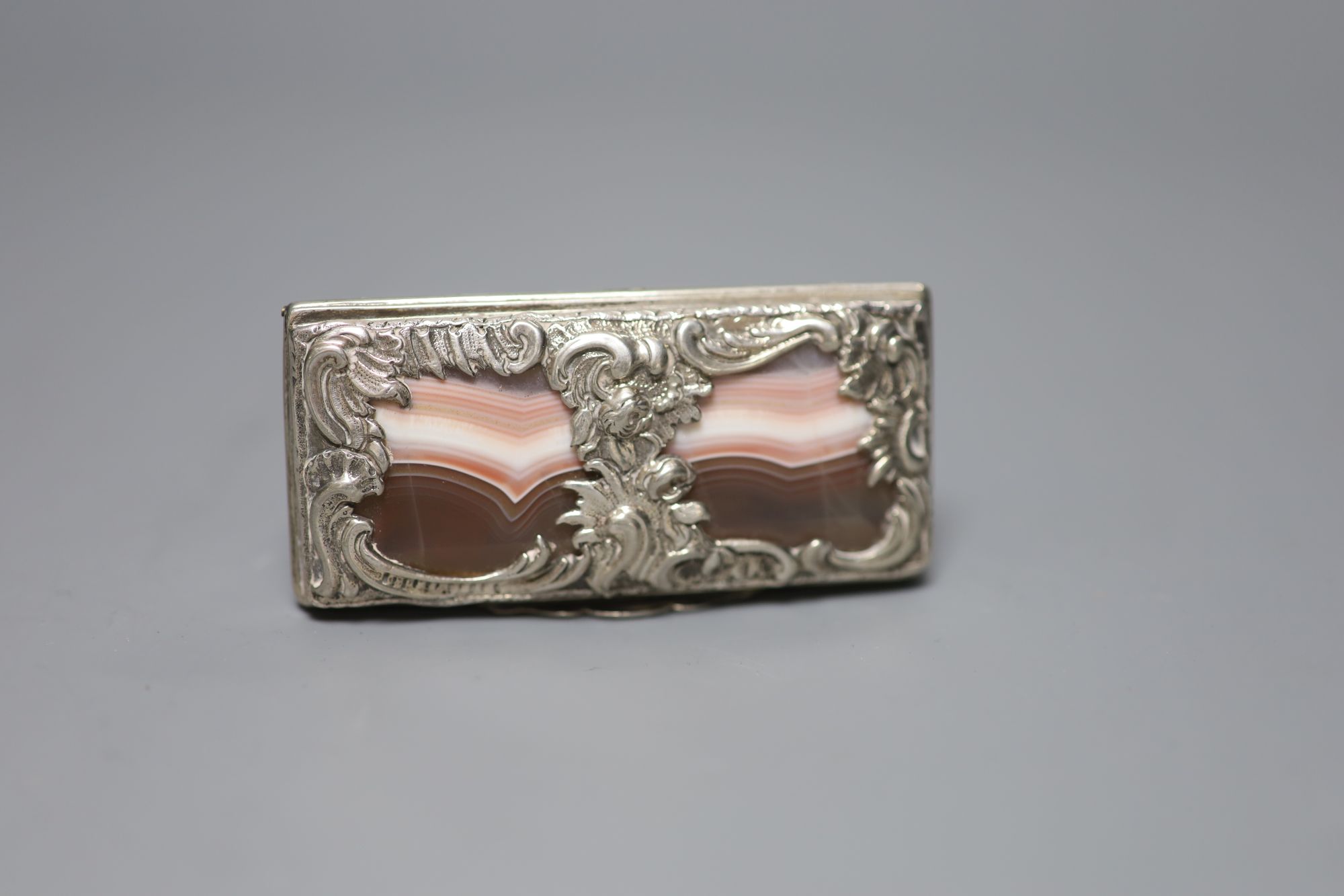 A white metal mounted banded agate snuff box, unmarked, 76mm (agate cracked in several places).